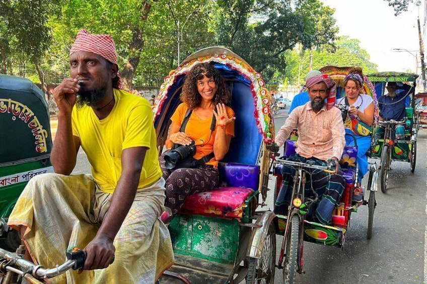 A group of people riding colorful rickshaws on a street. 5