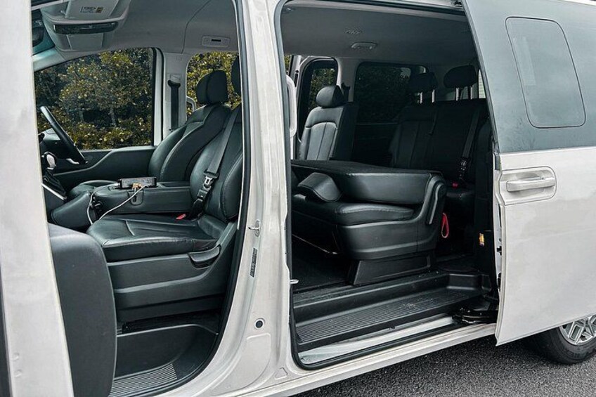 A vehicle interior with black leather seats, a steering wheel, and a gear shift. 4