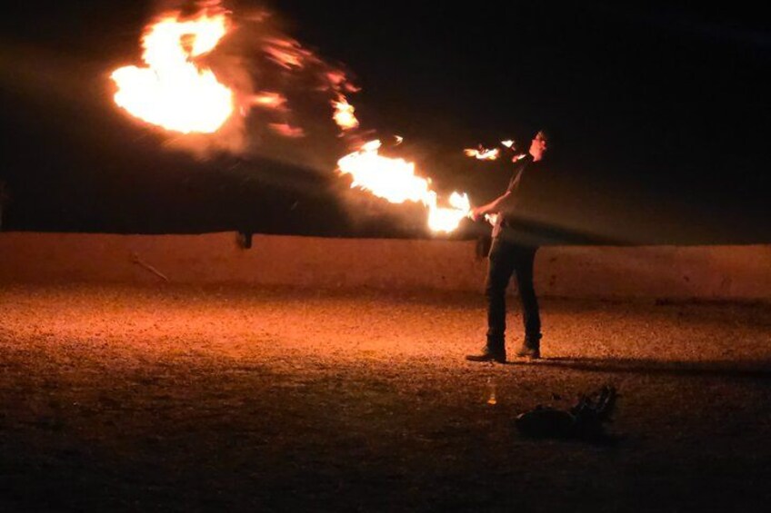 A person performing fire tricks with a flaming object. 5