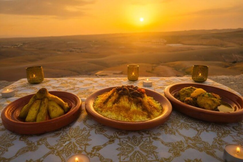 A table with traditional dishes and a desert landscape at sunset. 4