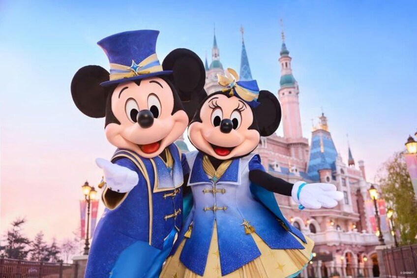 Mickey and Minnie Mouse in front of a castle with spires. 1