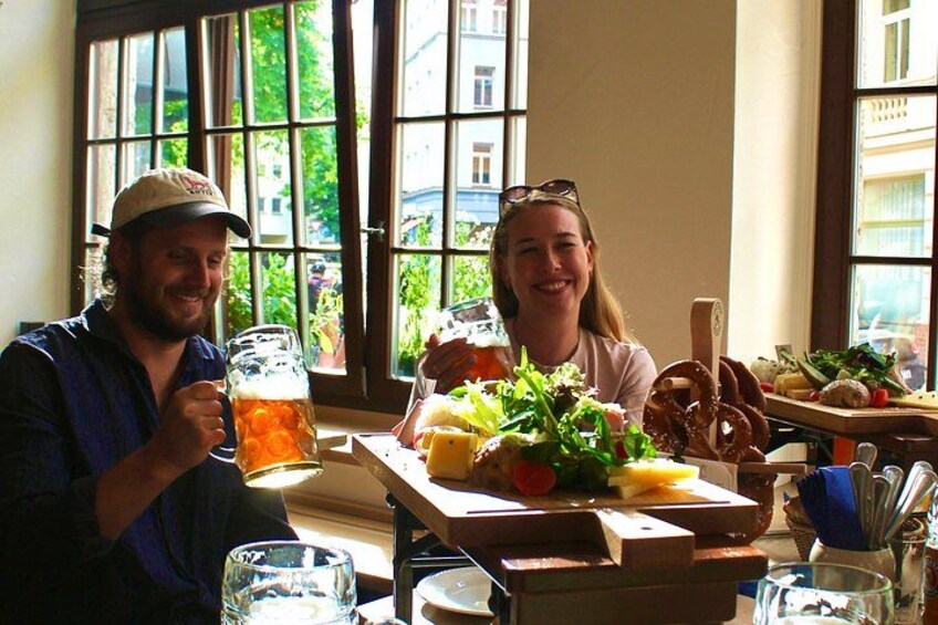 Two people sitting at a table with food and drinks. 3