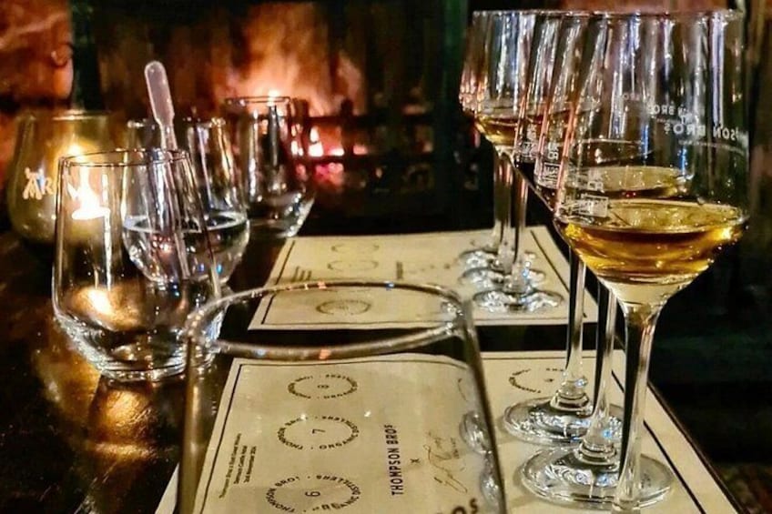 A bar setting with glasses of white wine and a menu. 2