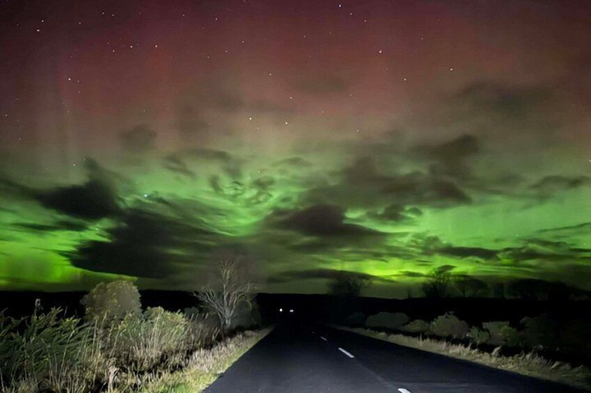 A road under a green aurora display. 2