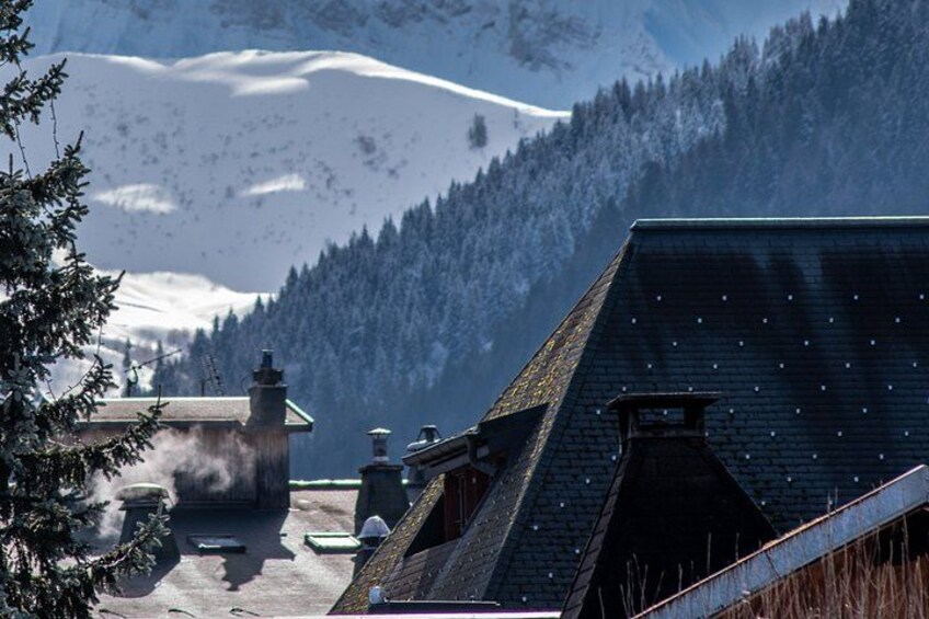 A snowy mountain landscape with a village, buildings, and a chimney emitting smoke. 2
