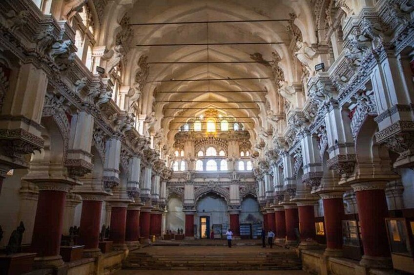 An ornate hall with high ceilings, intricate columns, and arched windows. 2