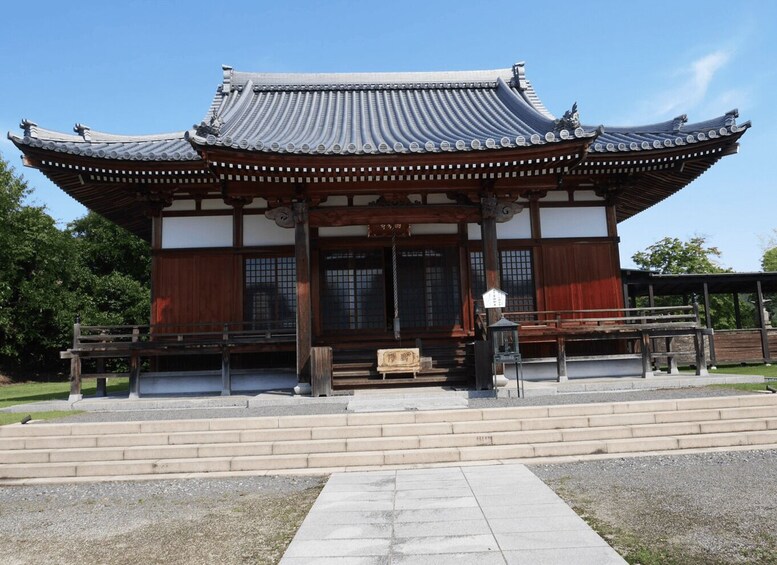 A traditional Japanese building with a tiled roof, wooden beams, and a stone pathway leading to the entrance. 4