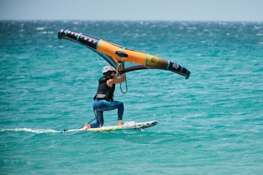 A person windsurfing on turquoise water. 1