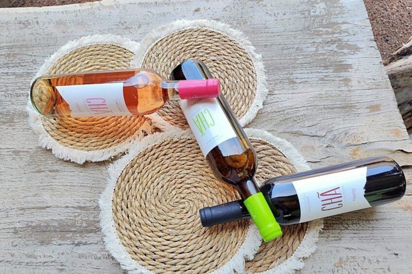 Three wine bottles on woven coasters. 2
