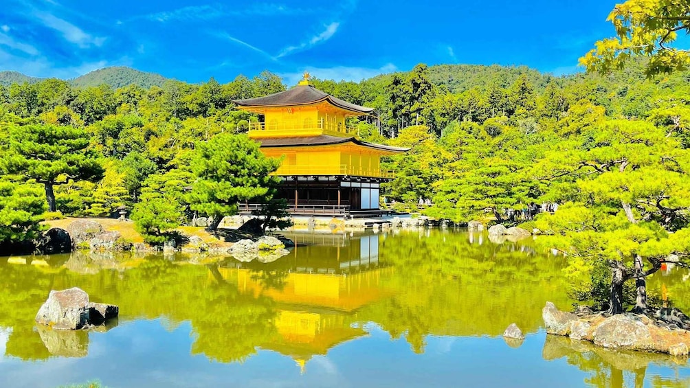 A traditional Japanese temple with a golden roof, surrounded by lush greenery and a calm pond reflecting the structure. 3