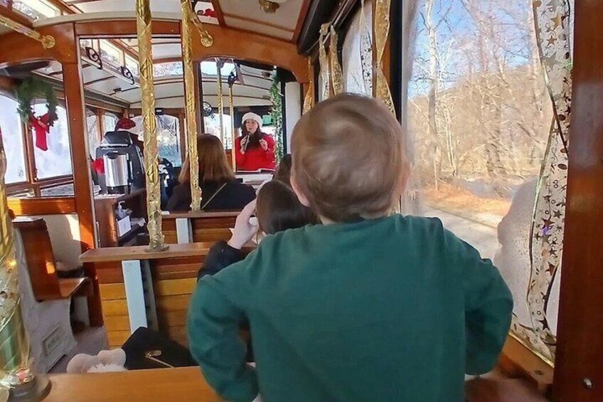 A child looking out a bus window, a person in a red jacket, and Christmas decorations. 5