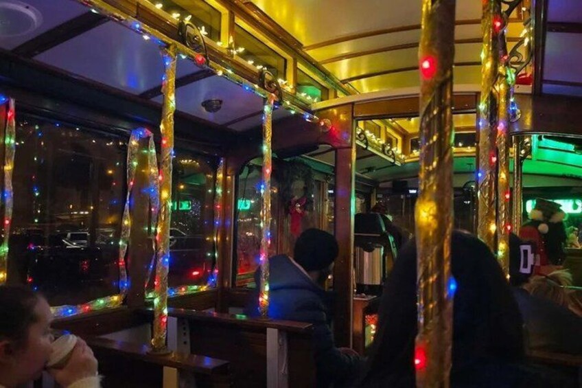 A bus interior with colorful lights and a person holding a cup. 3