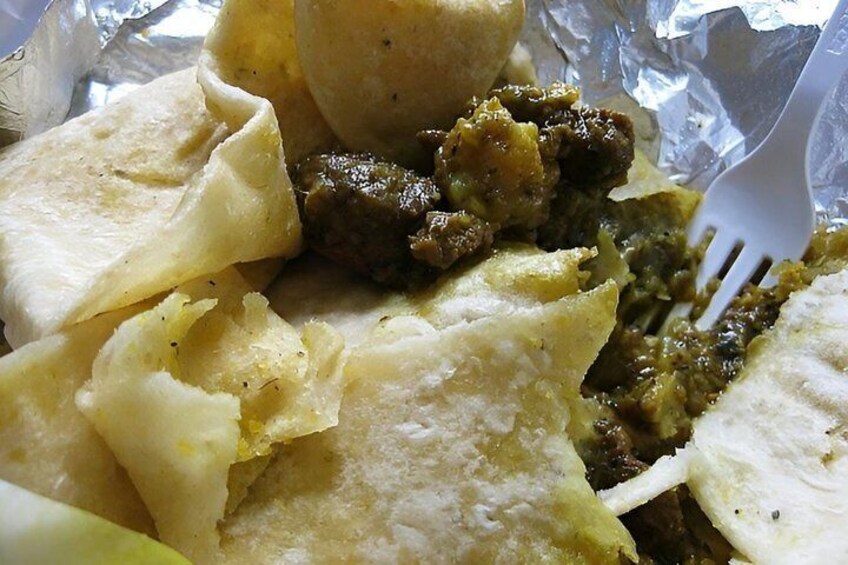 A meal with tortillas, a fork, and a green sauce. 2