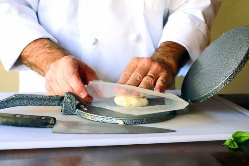A person in a white coat using a grater on a cutting board. 4