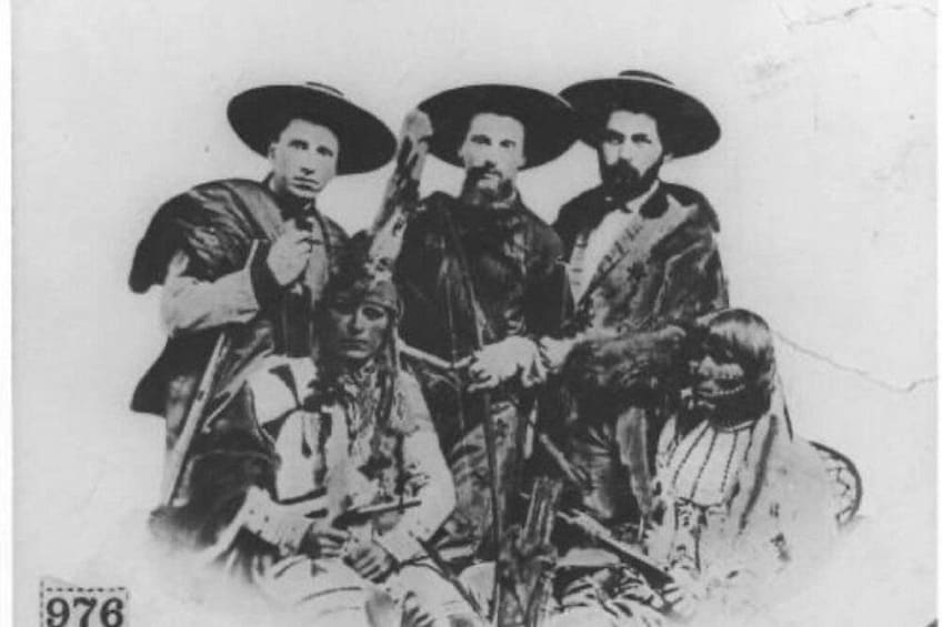 A historical group portrait with individuals wearing period clothing and hats. 3