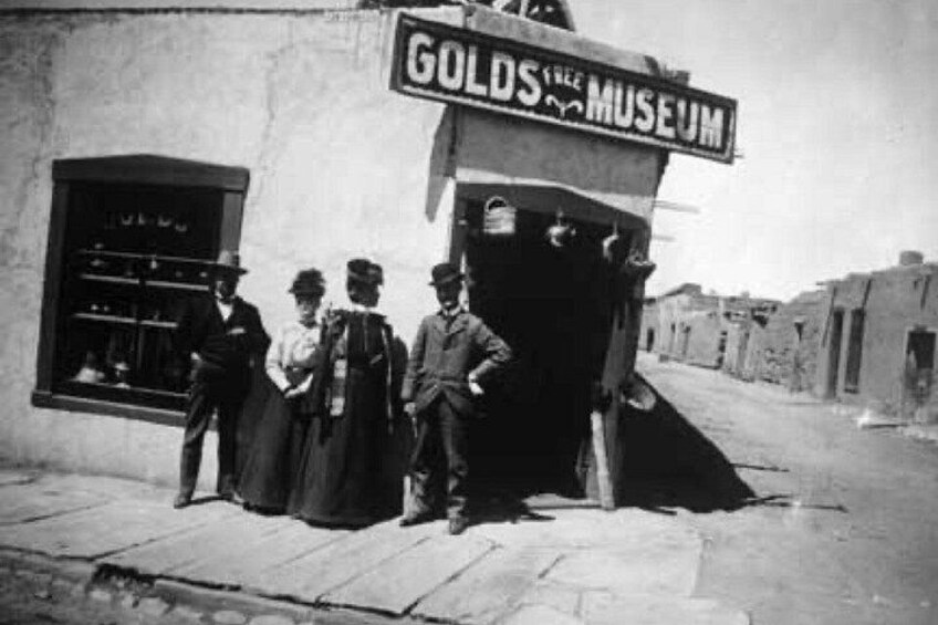 A street scene with a building labeled 'GOLDS FREE MUSEUM' and a storefront with a display window. 2