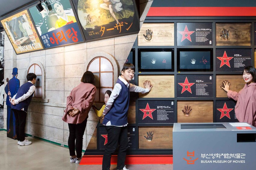 A museum exhibit with movie memorabilia and handprints on display. 5