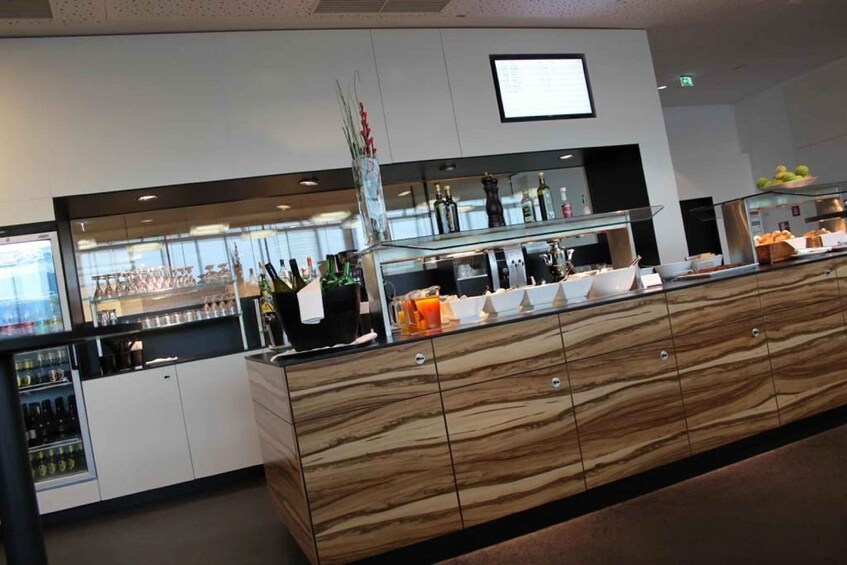 A modern buffet setup with a wooden counter, various food items, and a refrigerator. 5