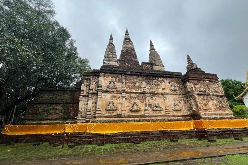 A temple with multiple spires and intricate carvings, surrounded by a yellow tarp. 3