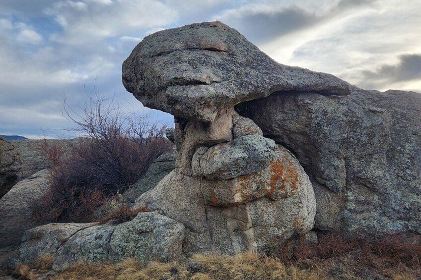 A large rock formation with a prominent overhang. 3