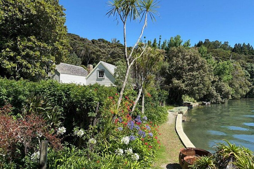 A house surrounded by lush greenery and a body of water. 2