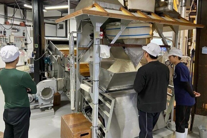 A food processing facility with large industrial machines and workers in protective gear. 2