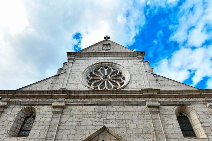 A church with a large circular window and a cross on top. 4