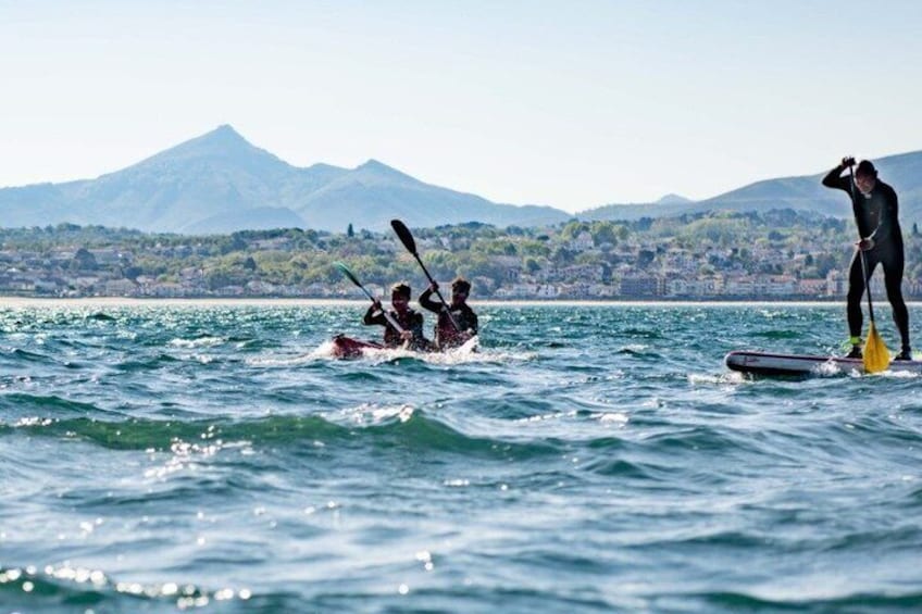 People paddleboarding on a lake with mountains in the background. 3