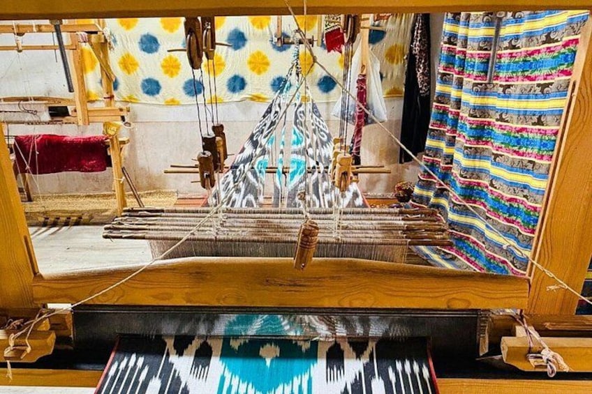 A loom with colorful textiles and wooden structures. 4
