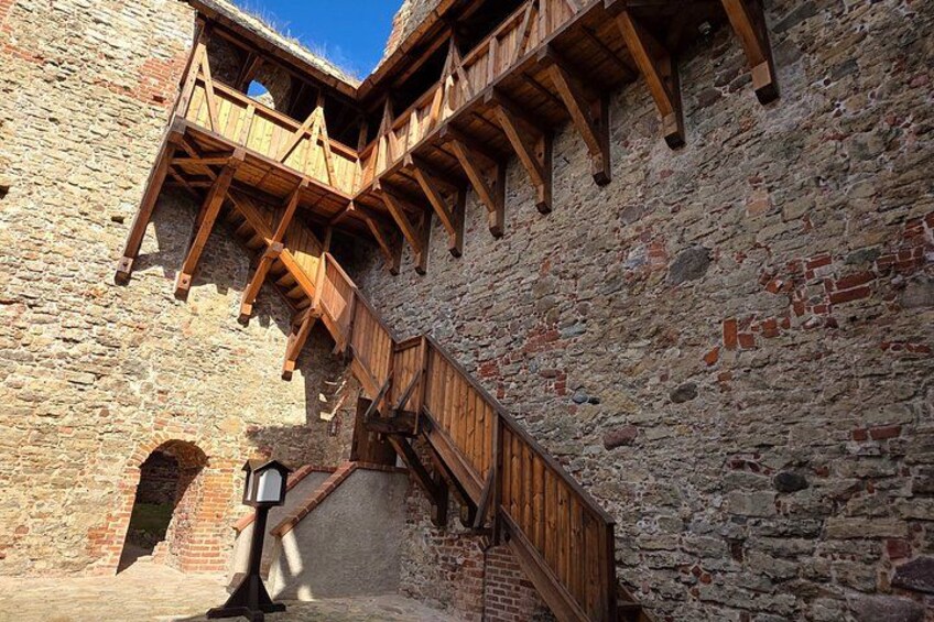 A stone building with wooden staircases and balconies. 3