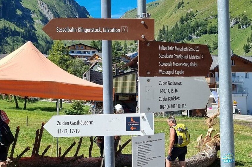 Directional signs at a mountain resort, including routes to Sesselbahn Klingenstock, Talstation, and various facilities. 3