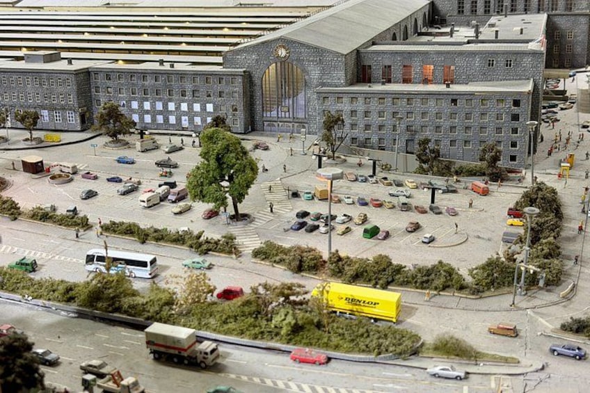 A model cityscape with buildings, roads, vehicles, and a large yellow truck. 2
