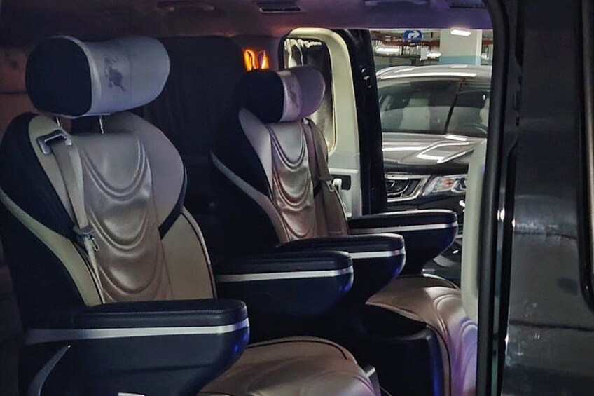A vehicle interior with two seats, a headrest, and a storage compartment. 5