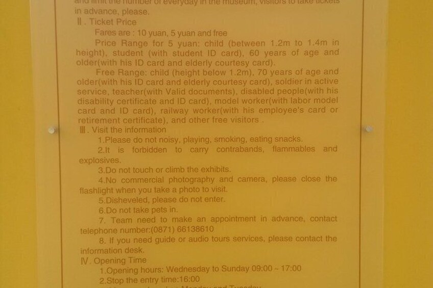 A yellow sign with text about museum ticket prices and visitor guidelines. 4