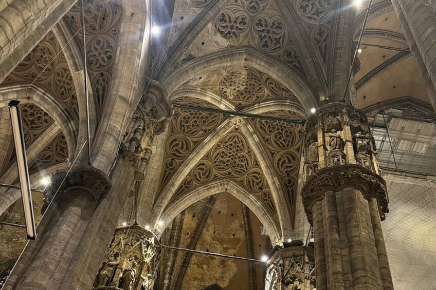 A cathedral interior with ornate Gothic arches and detailed stonework. 4