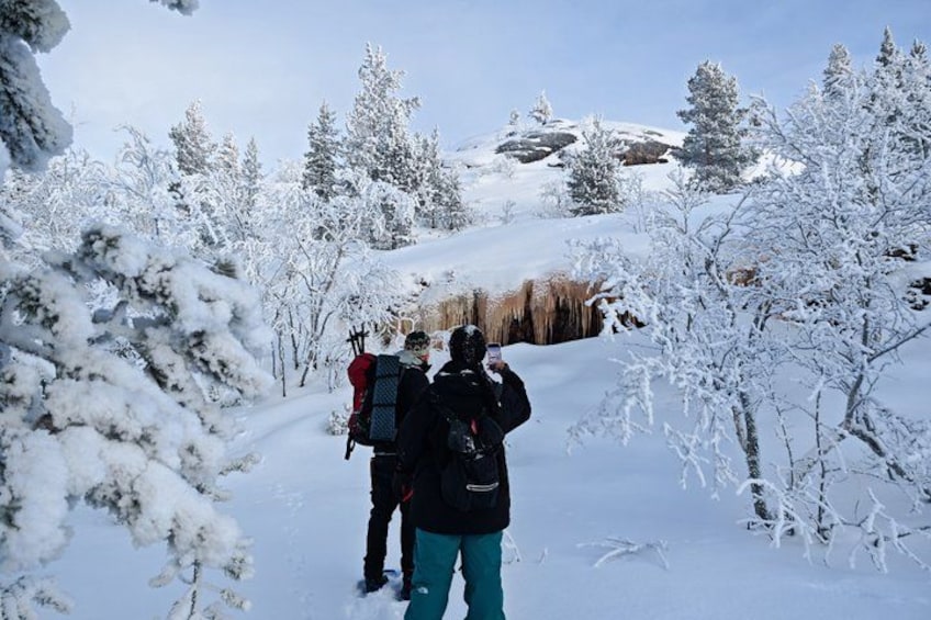 A snowy landscape with a group of people hiking. 4