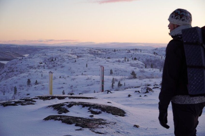 A person standing on a snow-covered hill with a sunset in the background. 2