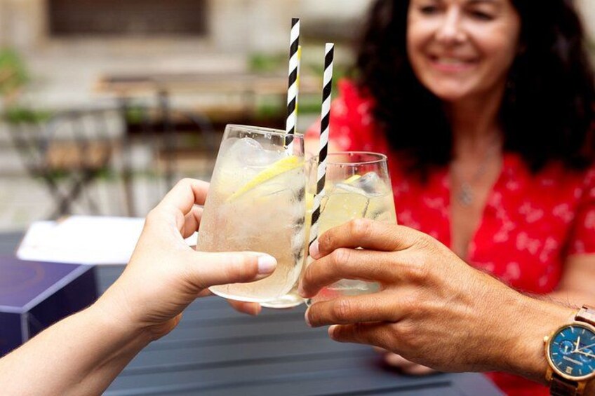Two people toasting with drinks that have lemon slices and striped straws. 3