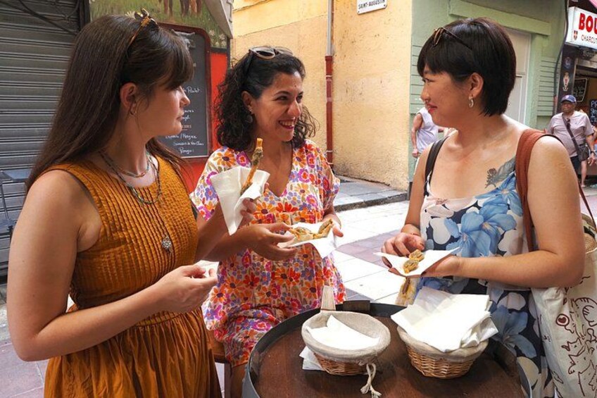 Three women eating at a street-side food stall. 5