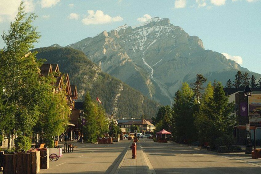 A mountain town with traditional buildings, a clear sky, and a prominent mountain in the background. 4