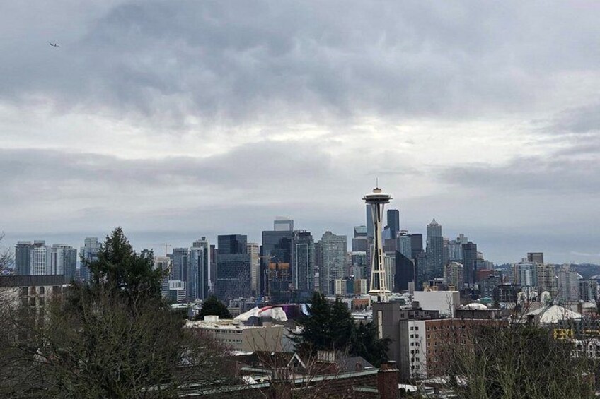 A city skyline with a prominent tower, various buildings, and a cloudy sky. 3