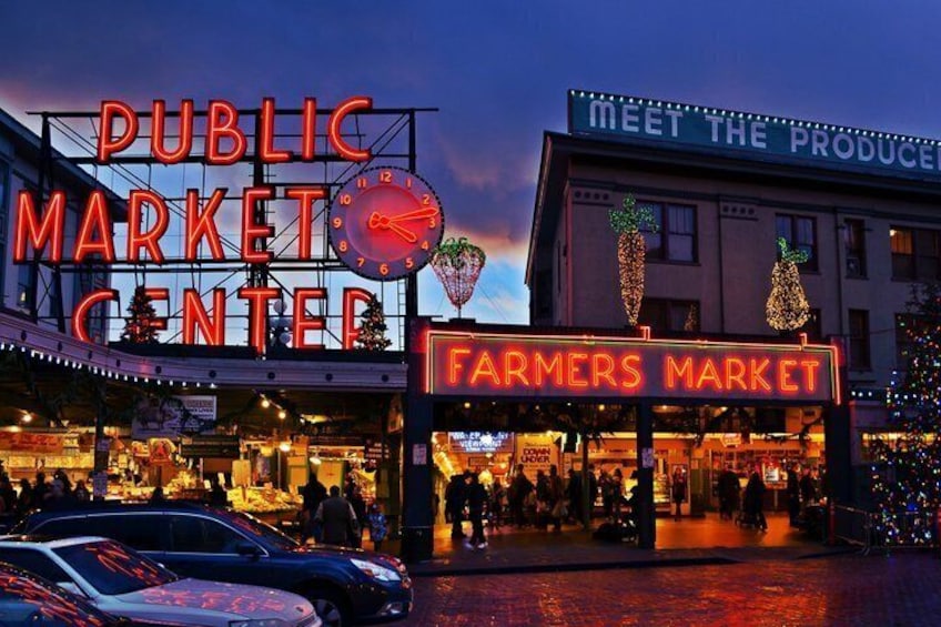 A public market center with a clock, a Farmers Market sign, and a Christmas tree. 1