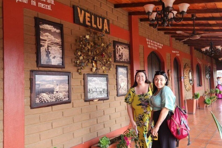 A brick wall with the word 'VELUA' and several framed pictures. 4