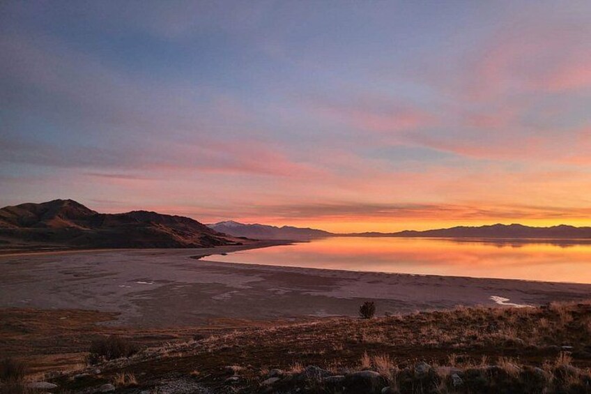 A sunset over a lake with mountains in the background. 5
