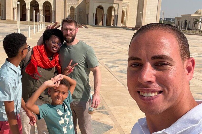 A group of people in a courtyard with a large building in the background. 2