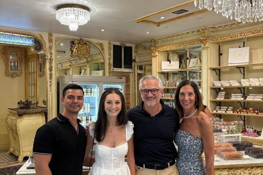 A luxury boutique interior with ornate gold detailing, a chandelier, and a display of jewelry. 4