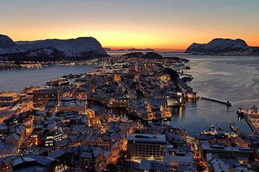 A coastal cityscape at sunset with snow-covered buildings and mountains in the background. 1