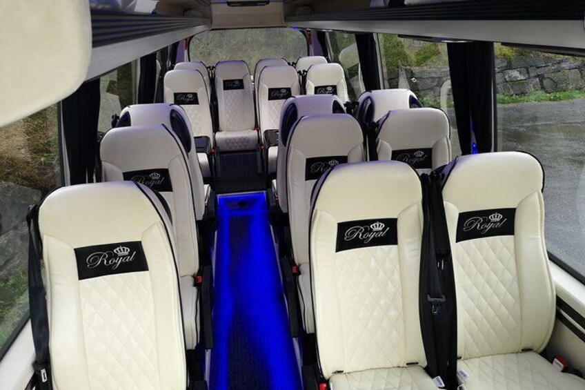 A bus interior with rows of seats, each with a 'Royal' label. 5