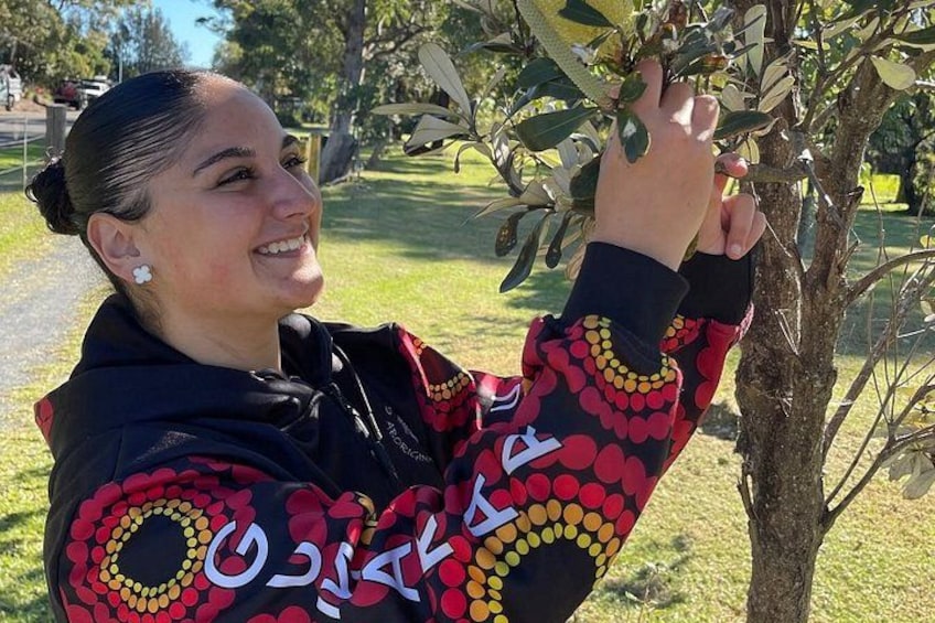 A person wearing a patterned jacket interacting with a tree. 2