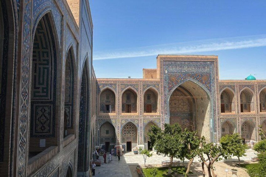 A courtyard with arched walkways, intricate tile work, and a central dome structure. 5